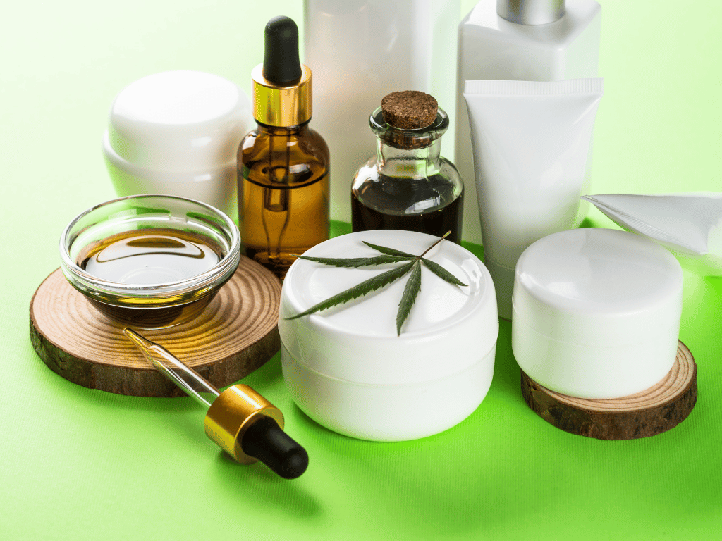 Verschiedene CBD-Kosmetikprodukte mit Hanföl und Cremes auf grünem Hintergrund