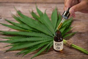 Flacon d'huile de CBD avec pipette sur socle en bois