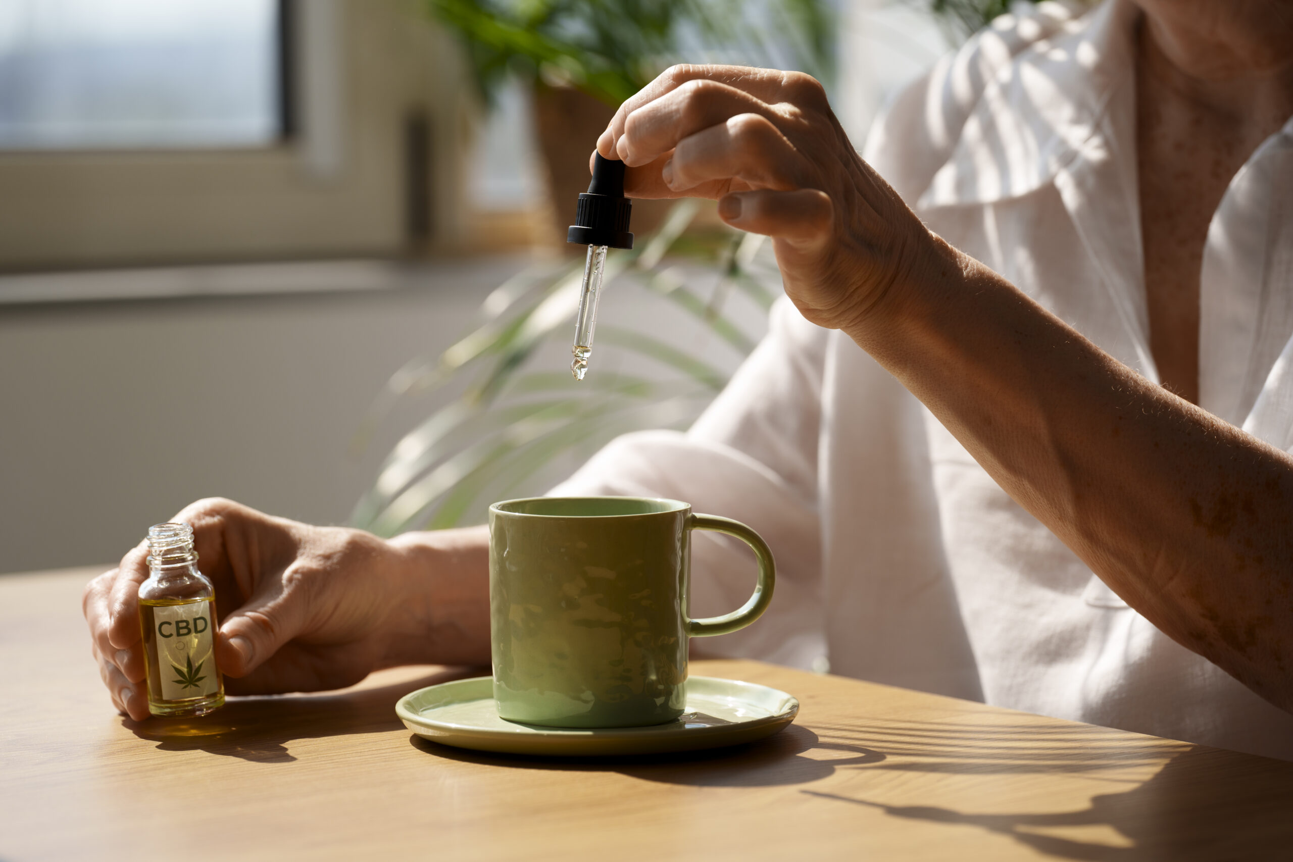 CBD-Öl mit Pipette über einer Tasse Tee